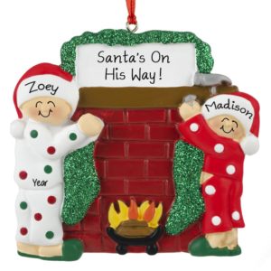 Image of Two Kids Hanging Stockings On Mantle Holiday Ornament
