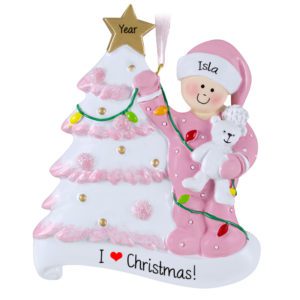 Image of Little Girl Decorating Glittered Tree And Holding Bear Ornament PINK